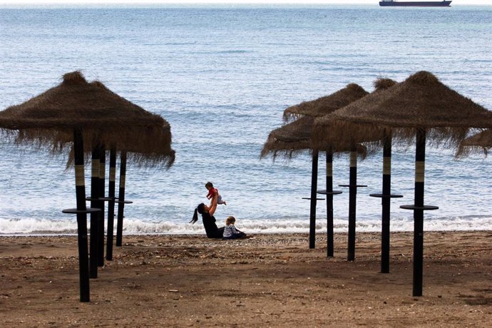 Una mujer con dos niños en la playa de La Malagueta el primer día en el que los menores de 14 años pueden salir, en Málaga (Andalucía ,España) a 26 de abril de 2020.