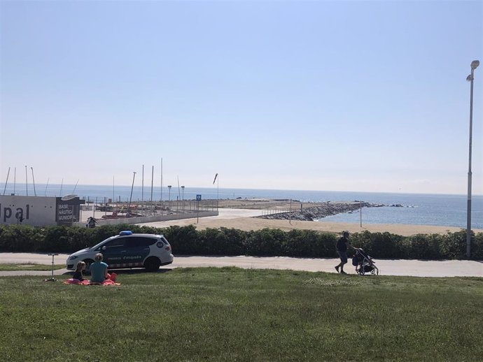 Adultos pasean con sus hijos cerca de una playa en Barcelona, en el primer día en el que se permite salir a los niños desde la declaración del estado de alarma por el coronavirus.