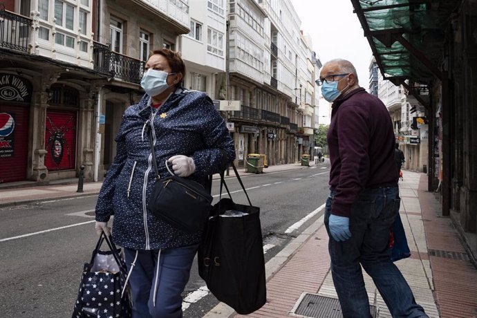 Transeúntes pasean con mascarillas por A Coruña en el día 41 del estado de alarma por la crisis sanitaria del Covid-19 donde tan solo están permitidos por el momento los desplazamientos para empleados de servicios esenciales, aquellos que no puedan tele