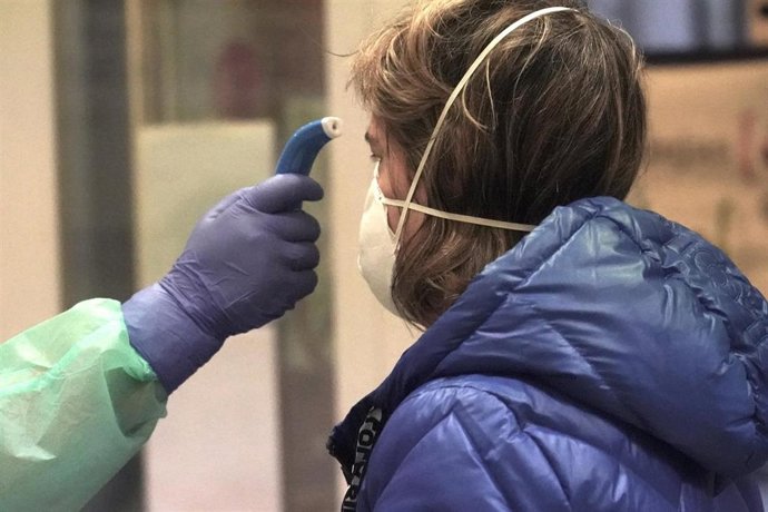 Un sanitario toma la temperatura a una de los paciente diagnosticados con COVID-19 a los que no se le realizó previamente test antes de realizar el cribado, en el centro de centro de salud de Osakidetza del casco viejo de Bilbao