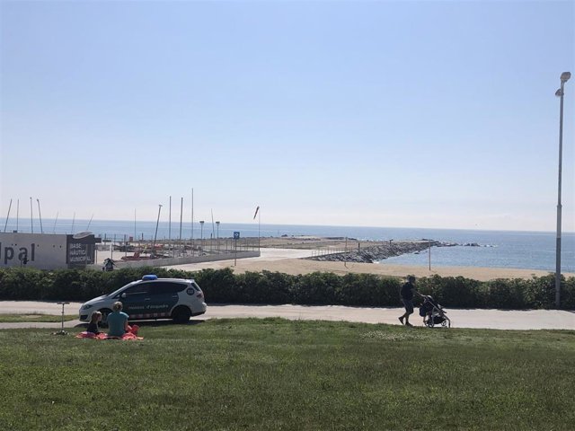 Adultos pasean con sus hijos cerca de una playa en Barcelona, en el primer día en el que se permite salir a los niños desde la declaración del estado de alarma por el coronavirus.
