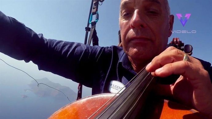Un violonchelista de 60 años toca el himno nacional estadounidense mientas hace parapente