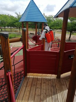 Un operario realiza labores de limpieza y desinfección en un parque.
