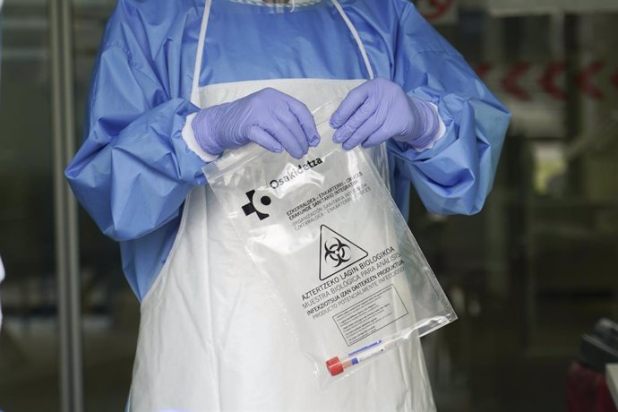 Un sanitario protegido con guantes sostiene una bolsa en la que hay una muestra para realizar un Análisis PCR en un local de Diputación de Bizkaia,  