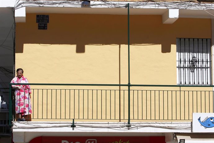 Una señora asomada a su balcón durante el periodo de confinamiento por la pandemia del COVID-19 en Málaga capital