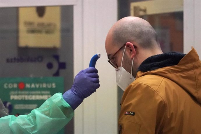 Un sanitario toma la temperatura a uno de los paciente diagnosticados con COVID-19 a los que no se le realizó previamente test antes de realizar el cribado, en el centro de centro de salud de Osakidetza del casco viejo de Bilbao