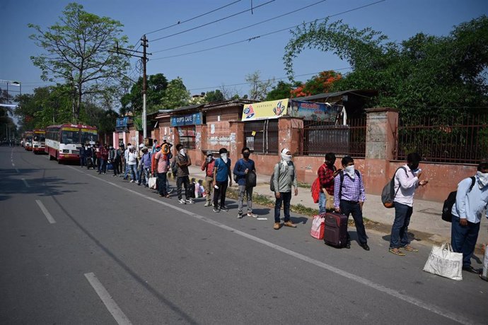 28 April 2020, India, Prayagraj: Students from different districts of Uttar Pradesh queue to board buses after Uttar Pradesh government arranged roadways buses to send students to their hometown during Government imposed nationwide lockdown as a prevent