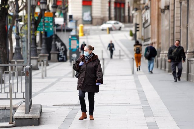 Una mujer con mascarilla pasea por la calle de Alcalá durante el primer día de la cuarta semana de estado de alarma decretado por el Gobierno para combatir el coronavirus, en Madrid (España) a 6 de abril de 2020.
