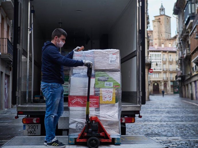 Un trabajador de reparto mueve productos de su camión aparcado en las calles de Pamplona que amanecen totalmente vacías durante la tercera semana de cuarentena y confinamiento total decretado en España como consecuencia del coronavirus, en Pamplona, Nav