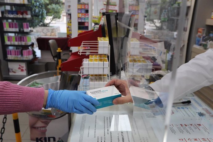 Un farmacéutico vende una caja de Paracetamol en su farmacia durante el segundo mes de confinamiento, en Madrid (España) a 20 de abril de 2020.