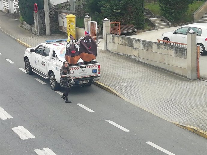 Vehículo de Protección Civil con dos personas disfrazadas de castaña y la alcaldesa de Vilariño de Conso