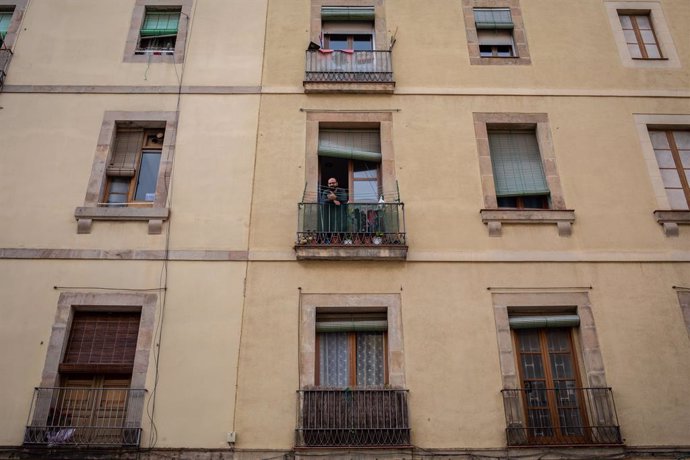 Un home treu el cap a la balconada durant el tercer dia laborable de l'estat d'alarma per coronavirus, a Barcelona/Catalunya (Espanya) a 18 de mar de 2020.