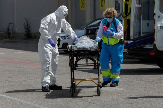 Dos sanitarios del SUMMA trasladan una camilla hacia el interior del hospital temporal de IFEMA para el posterior traslado de un paciente desde la UVI de IFEMA al Hospital Puerta de Hierro.