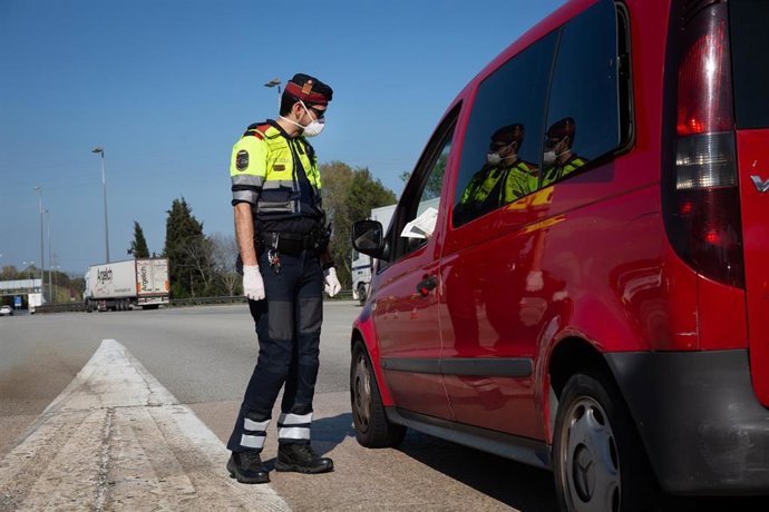 Un agente de los Mossos d'Esquadra protegido con una mascarilla en un control en el peaje de La Roca del Valls 
