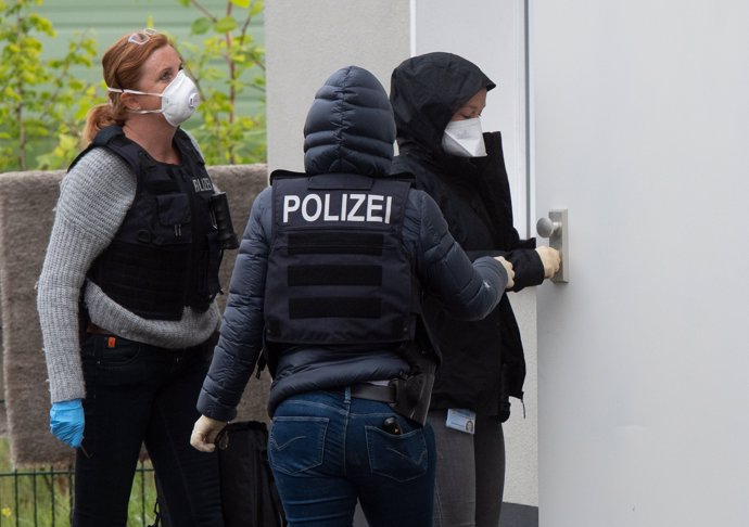 30 April 2020, North Rhine-Westphalia, Dortmund: Policewomen open a door in an outbuilding of the house where the Community of Lebanese Emigrants. Photo: Bernd Thissen/dpa