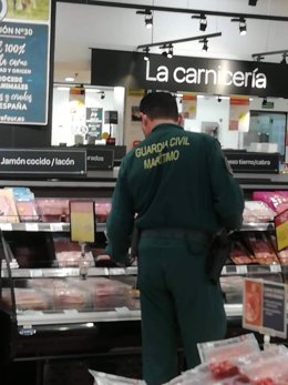 Un agente de la Guardia Civil, adquiriendo comida para entregarla en las acciones solidarias