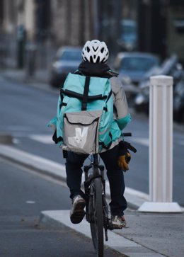 March 25, 2020 - Paris, France: A man on a bicycle doing food delivery for Deliveroo, rides on an empty bicycle line near Saint-Michel. (Mehdi Chebil/Contacto)