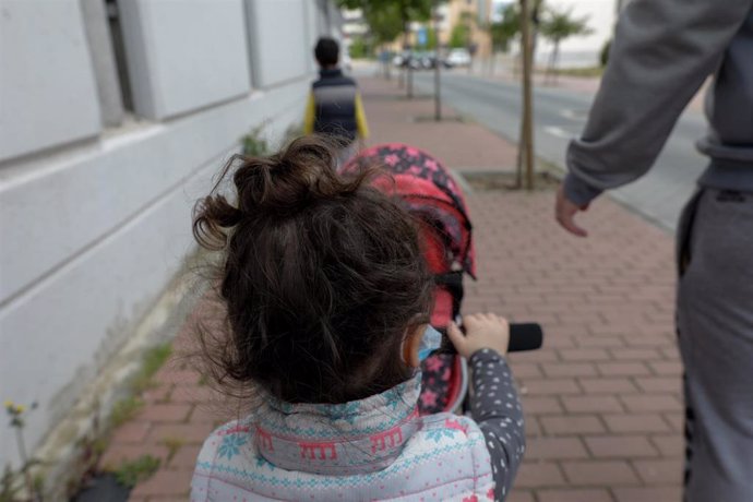 Dos niños pasean por la calle junto a su padre durante el segundo día de desconfinamiento. En Madrid (España) a 27 de abril de 2020.