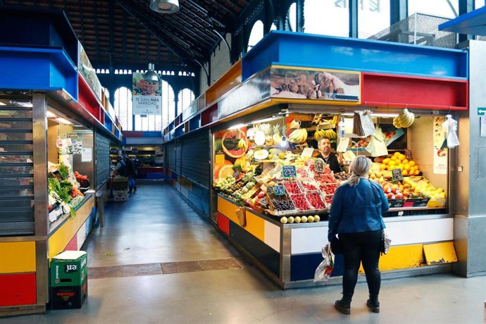 Un cliente compra en uno de los pocos puestos del Mercado de Atarazanas que permanecen abierto mientras los otros han cerrado a consecuencia de la pandemia del COVID-19. Málaga a 25 de marzo del 2020