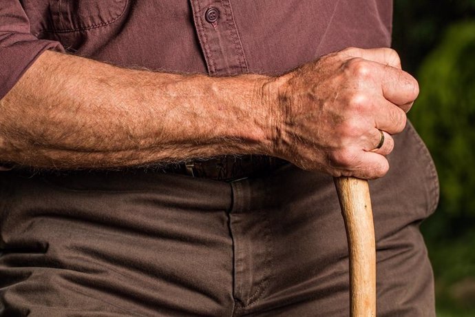 Una persona mayor con bastón.