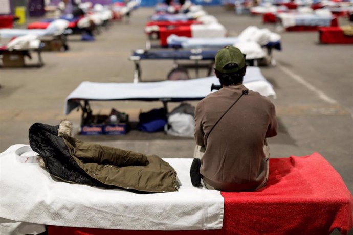 Un hombre sin hogar sentado en una de las camas del Pabellón 14, destinado a las personas sin hogar