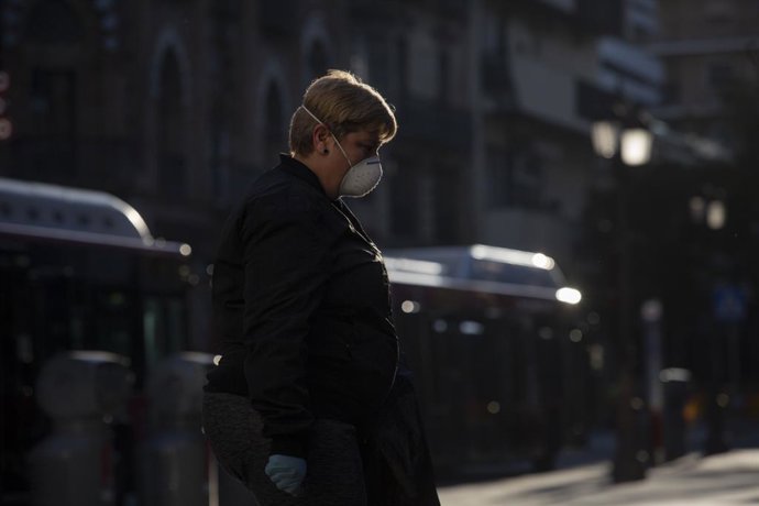 Una dona protegida amb mscara i guants camina pel carrer un dia després que el Govern d'Espanya anunciés les mesures de desescalada per la pandmia, Sevilla (Andalusia, Espanya), 29 d'abril del 2020.