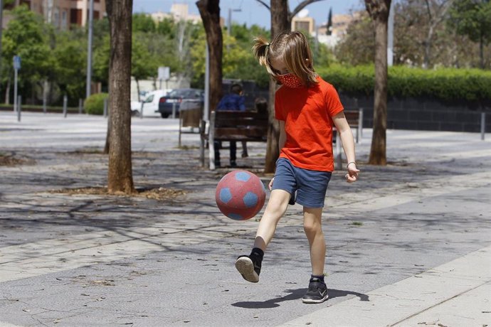 Una niña juega con un balón en una calle de Palma.