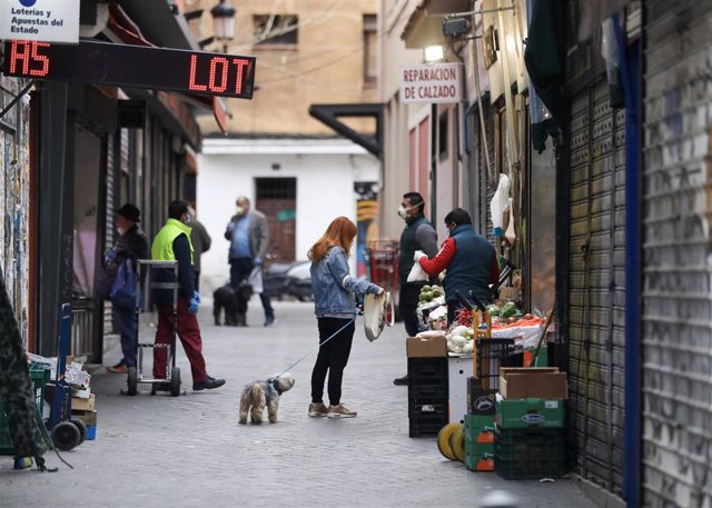 Una calle de la capital donde transeúntes realizan compras de primera necesidad en los pocos comercios abiertos, durante los inicios del segundo mes de confinamiento por la crisis del coronavirus. En Madrid, (España), a 14 de abril de 2020.