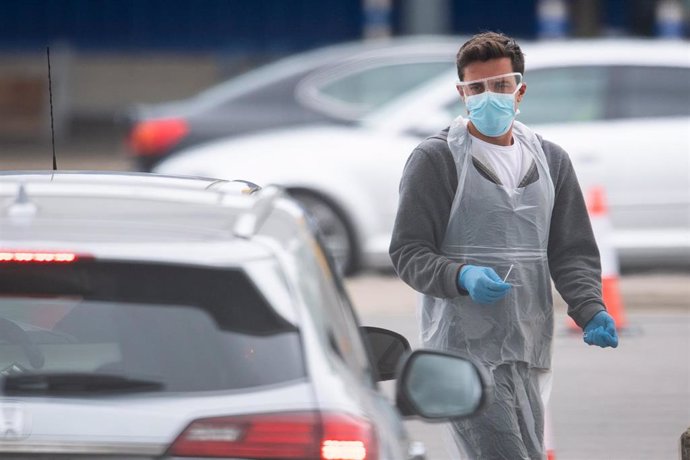 30 April 2020, England, London: A medic wearing protective equipment holds a test swab at a drive through coronavirus testing site at IKEA in Wembley. Photo: Dominic Lipinski/PA Wire/dpa
