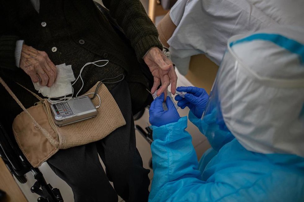 Un voluntario de la ONG Proactiva Open Arms realiza un test rápido de Covid-19 extrayendo sangre a un residente de la Residencia Geriátrica Redós de Sant Pere de Ribes dentro de un ensayo clínico realizado a trabajadores sanitarios de centros de mayores