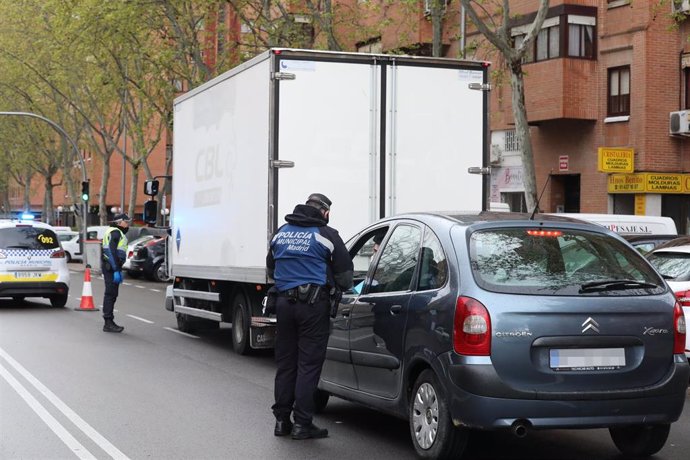 Dos policías municipales le piden la documentación a los conductores de dos vehículos, uno de ellos un particular y otro un camión, en un control de policial en el municipio madrileño de Vallecas para vigilar que todos aquellos que se salen durante el c