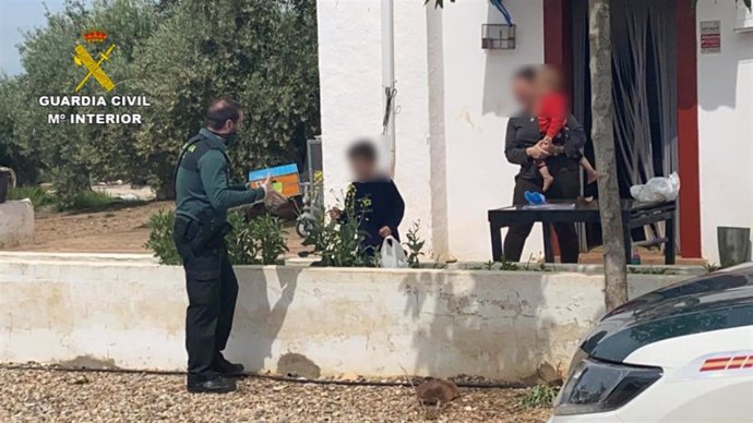 Imagen del momento en que un agente de la Guardia Civil entrega material a un alumno en la provincia de Córdoba. 