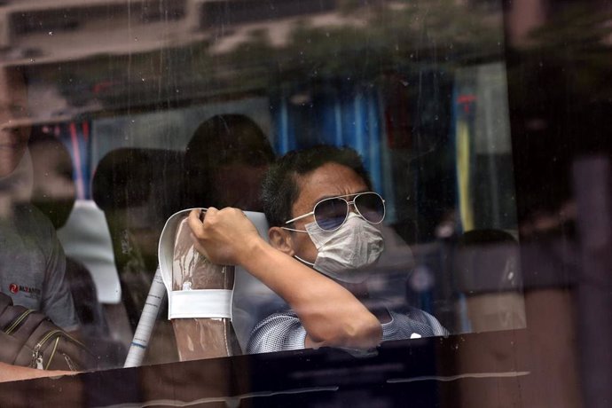 Un pasajero de un autobús con mascarilla en Filipinas.