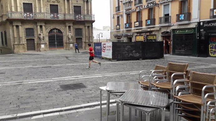 Una persona corriendo en la plaza del Ayuntamiento de Pamplona en el primer día en que se permite hacer ejercicio al aire libre