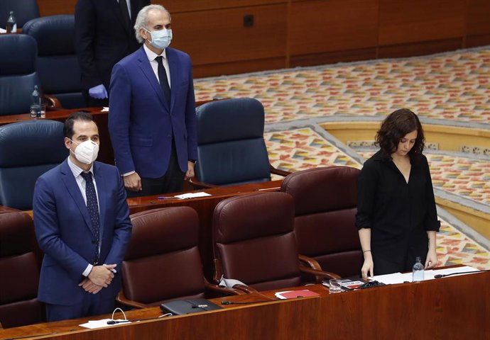 La presidenta de la Comunidad de Madrid, Isabel Díaz Ayuso (d), y el vicepresidente, Ignacio Aguado (i), guardan un minuto de silencio durante el pleno en la Asamblea de Madrid, celebrado este miércoles con un único punto del orden del día, la comparece