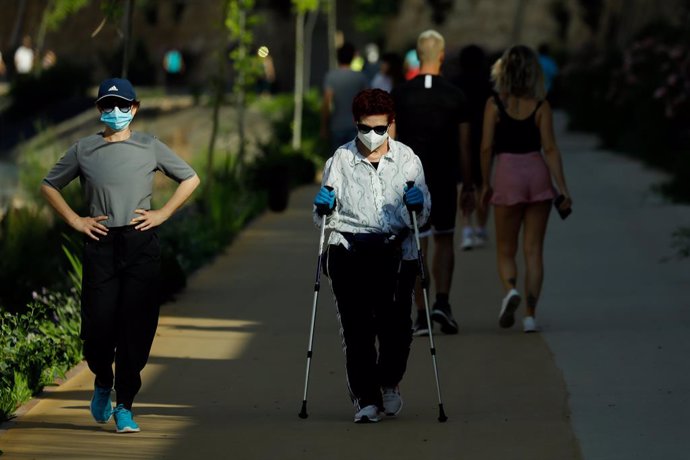 Diversos adults passegen i fan exercici amb mascarillas al costat del riu Segura, a Múrcia (Espanya), a 2 de maig de 2020.