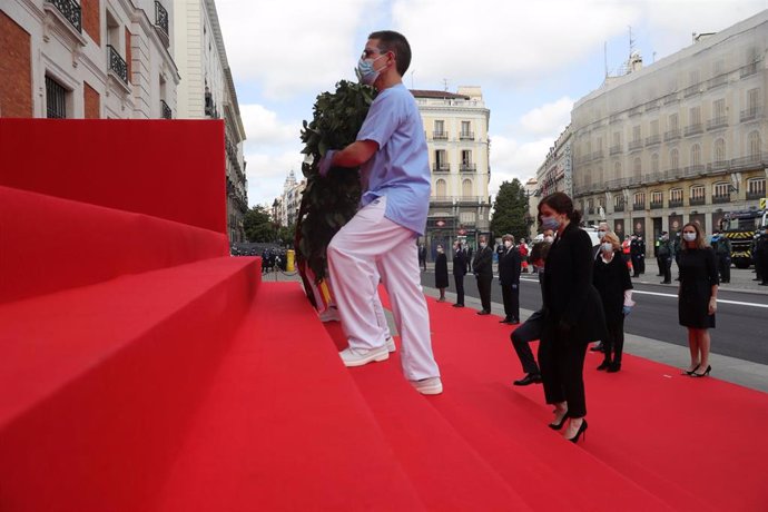 La presidenta de la Comunidad de Madrid, Isabel Díaz Ayuso (3-d) deposita una corona ante la placa en memoria de los caídos del 2 de mayo acompañada por dos sanitarios este sábado 2 de Mayo, durante las celebraciones de la fiesta de la Comunidad de Madr