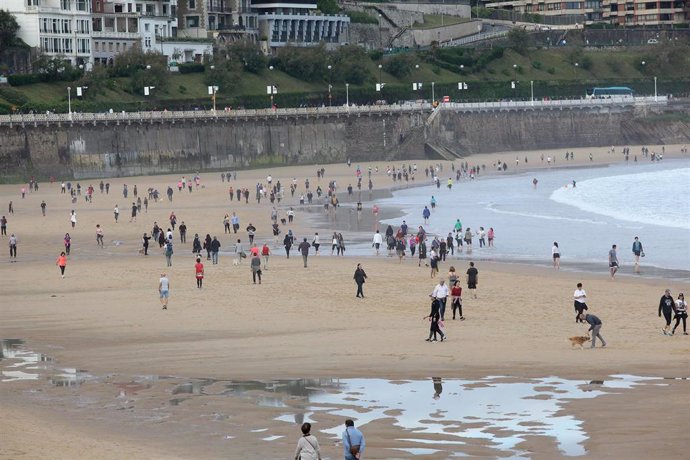 Grupos de personas en la playa de La Concha en el día en que el Gobierno permite salir a hacer deporte de forma individual y pasear con otra persona con la que se conviva, a determinadas horas,  San Sebastián a 2 de mayo de 2020.