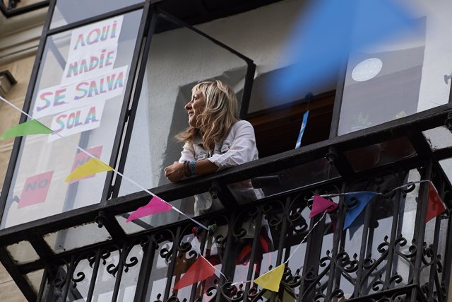 Una mujer mira desde la ventana de su casa de Madrid durante el confinamiento