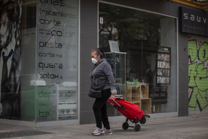 Una mujer protegida con mascarilla y guantes