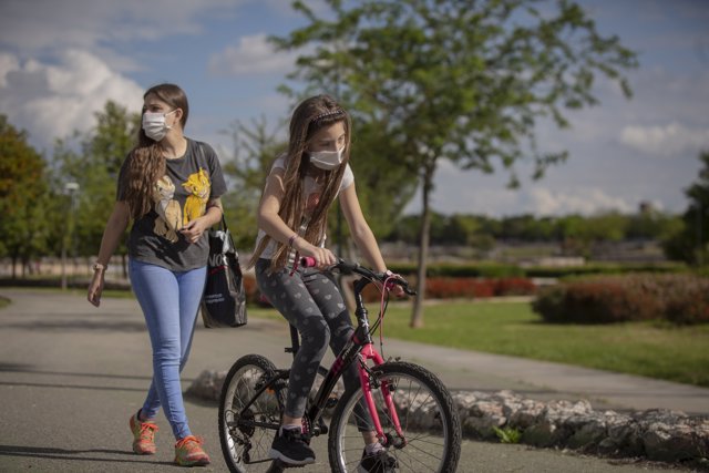 Una mujer con su hija pasean por el parque en el tercer día de desconfinamiento de niños y preadolescentes durante el estado de alarma. En Sevilla (Andalucía, España), a 28 de abril de 2020