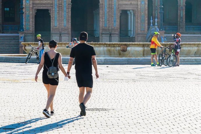 Una pareja cogidos de la mano  en  la Plaza de España,  el segundo día en que el Gobierno permite salir a hacer deporte de forma individual y pasear 
