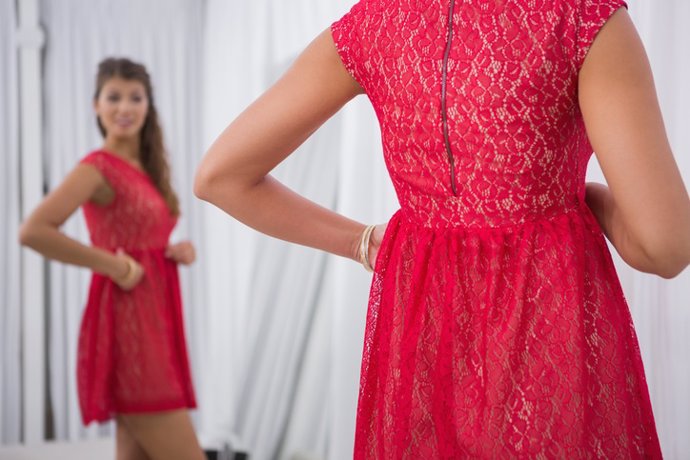Smiling woman trying on a red dress