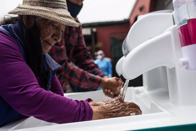 Mujer lavándose las manos en Lima, Perú