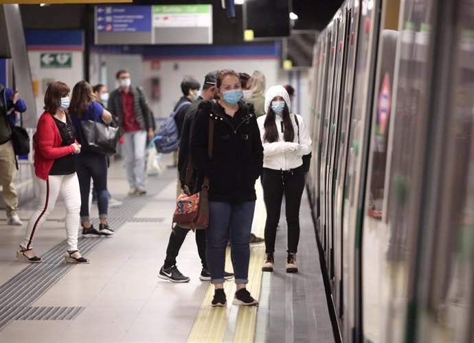 Viajeros con mascarillas en un andén de la estación de metro de Nuevos Ministerios durante la fase 0 de la desescalada del Gobierno