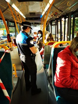 Un agente repartiendo mascarillas en la villavesa.