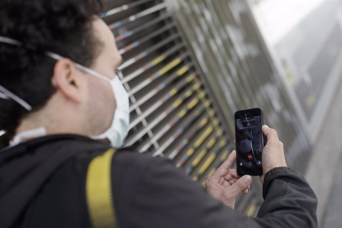 Un hombre protegido con mascarilla realiza una videollamada por su teléfono móvil en Madrid el 24 de abril de 2020.