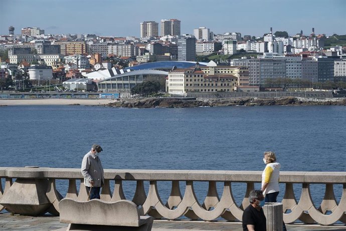 Dos personas pasean por el paseo marítimo de A Coruña (Galicia) en el segundo día en que el Gobierno permite salir a hacer deporte de forma individual y pasear según horarios y edades.