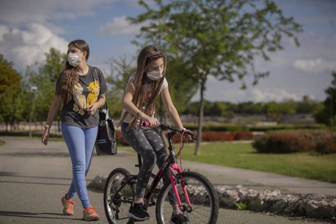 Una mujer con su hija pasean por el parque en el tercer día de desconfinamiento de niños y preadolescentes. En Sevilla (Andalucía, España), a 28 de abril de 2020