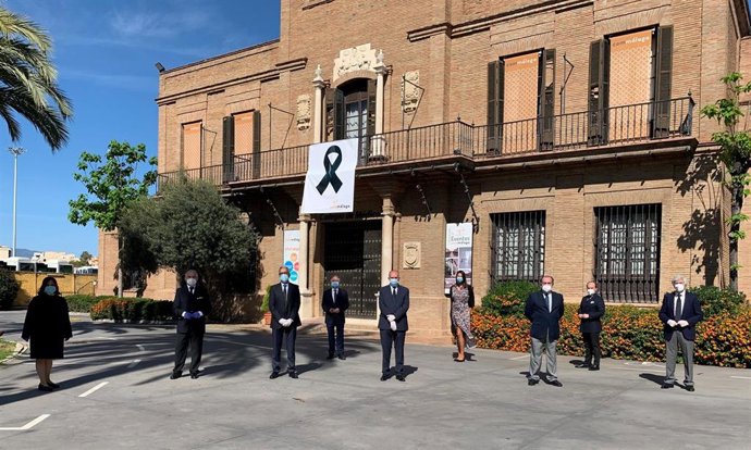 La junta directiva del Colegio de Médicos de Málaga guarda un minuto de silencio ante la fachada de su sede, que luce crespón negro